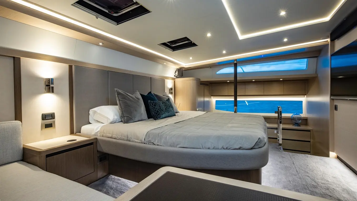 Luxurious yacht cabin featuring a double bed, stylish decor, soft lighting, and ocean views through large windows.